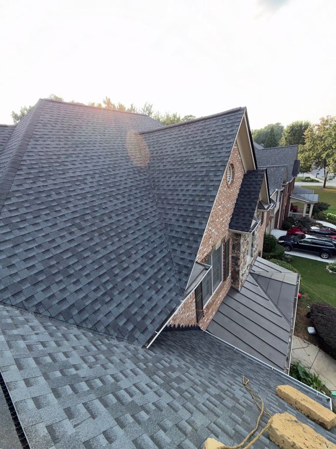 Complex roof with multiple hips and a dormer on a brick home