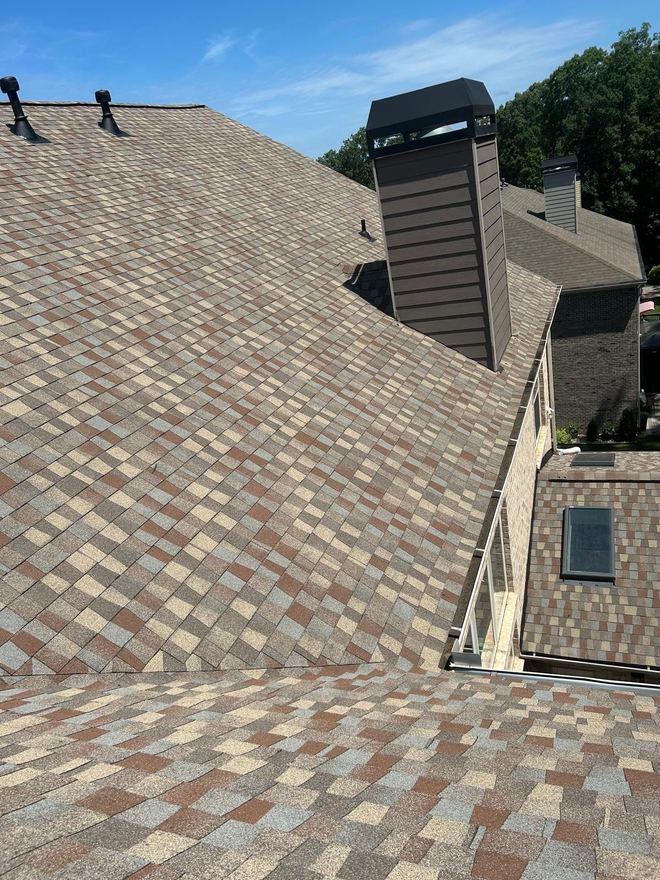 Multi-tone shingle roof with a sided chimney chase and a skylight