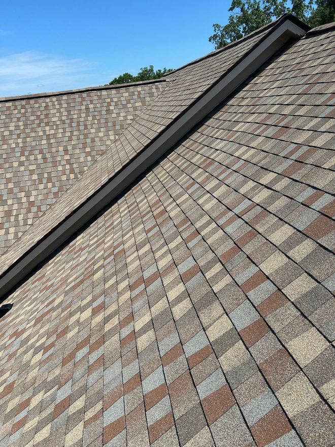 Two slopes of blended multi-tone shingles meeting at the hip