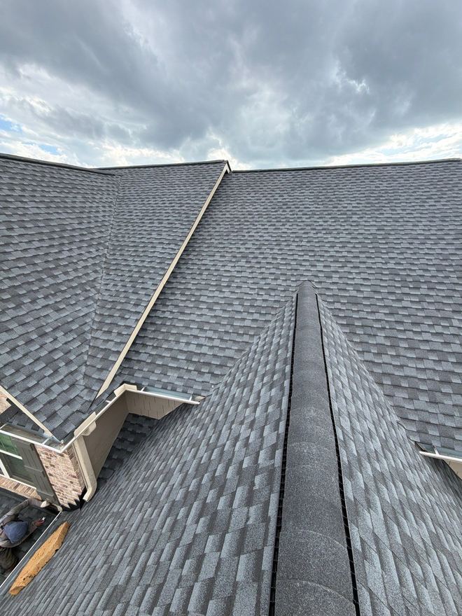 Two slopes of a new roof meeting at the ridge on an overcast morning