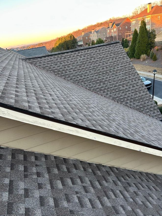 New roof at golden hour, with homes on the ridge line behind