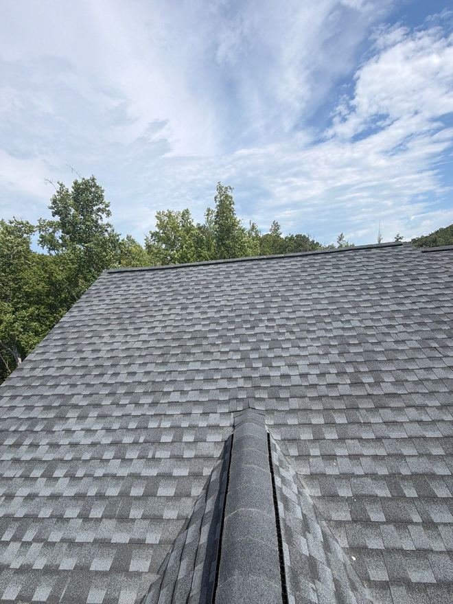 Fresh ridge cap shingles against a bright blue sky