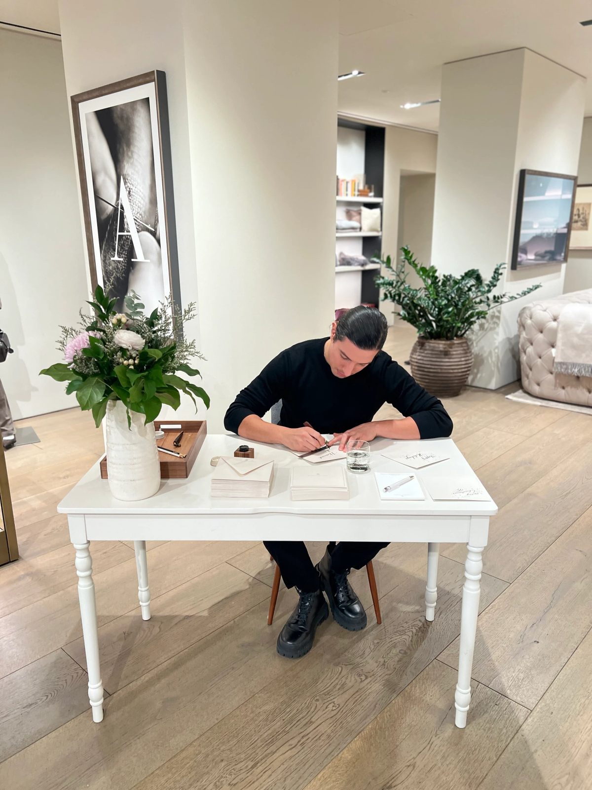 Artist writing cards at a white table