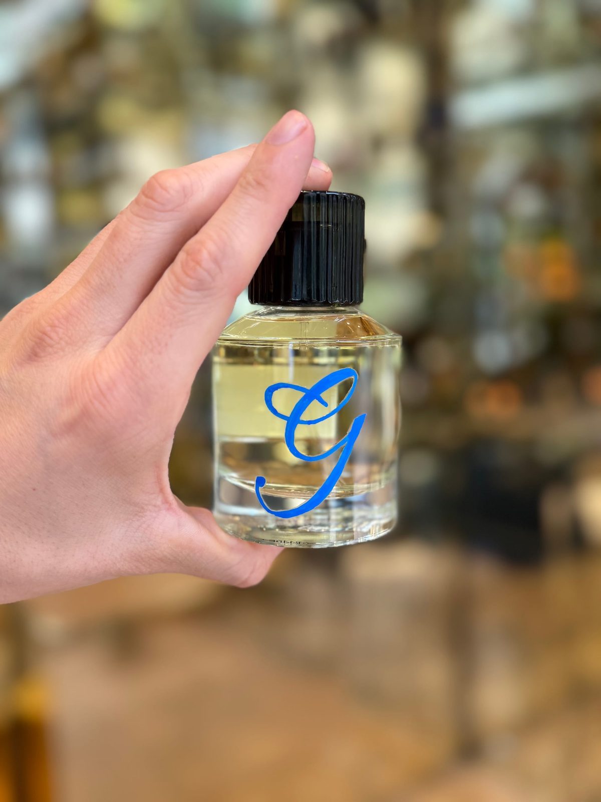 Blue hand lettering on a fragrance bottle