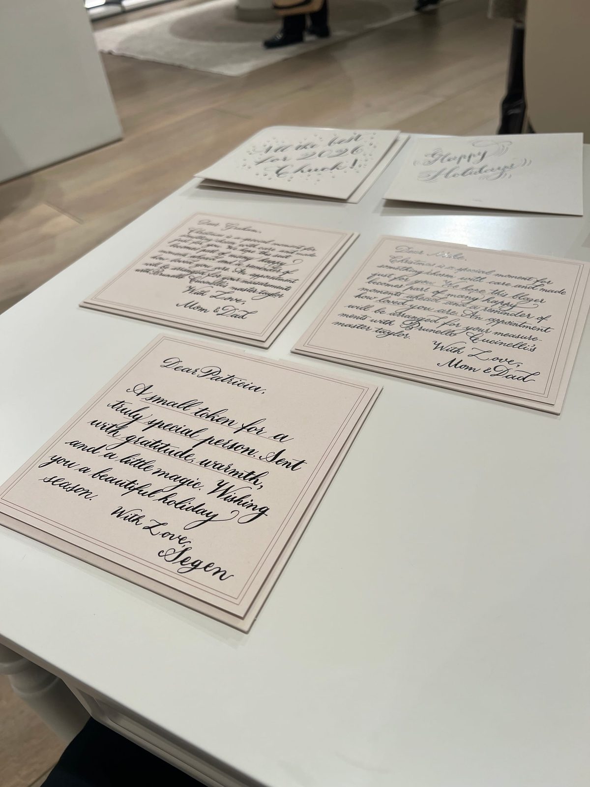 Holiday calligraphy cards arranged on the worktable