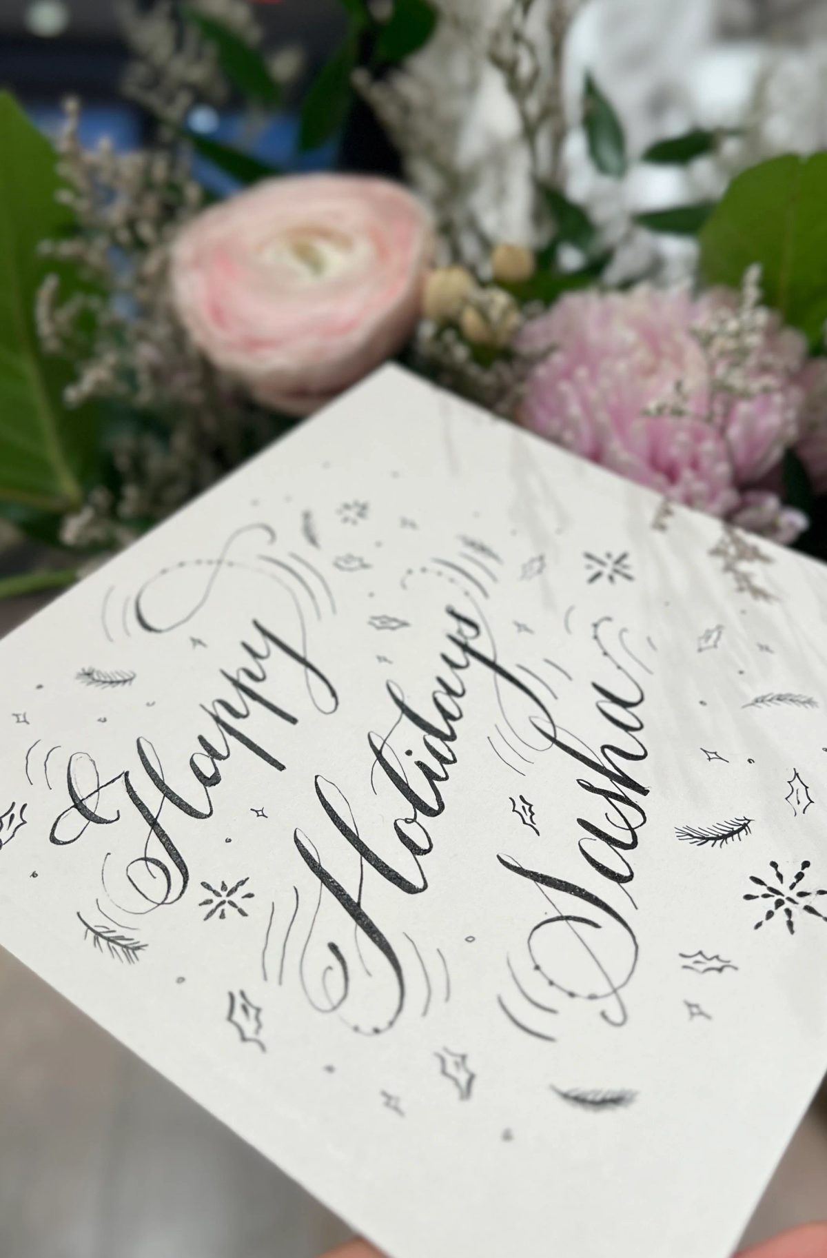 Flourished holiday calligraphy in black ink on white paper