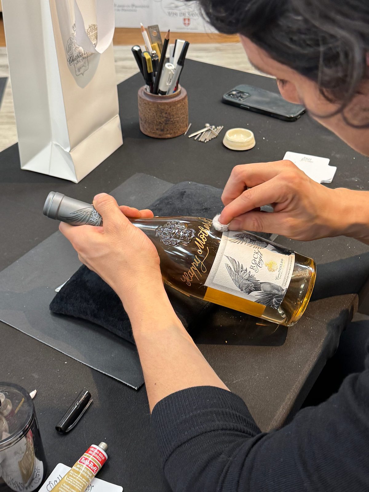 Rodolfo engraving a wine bottle by hand