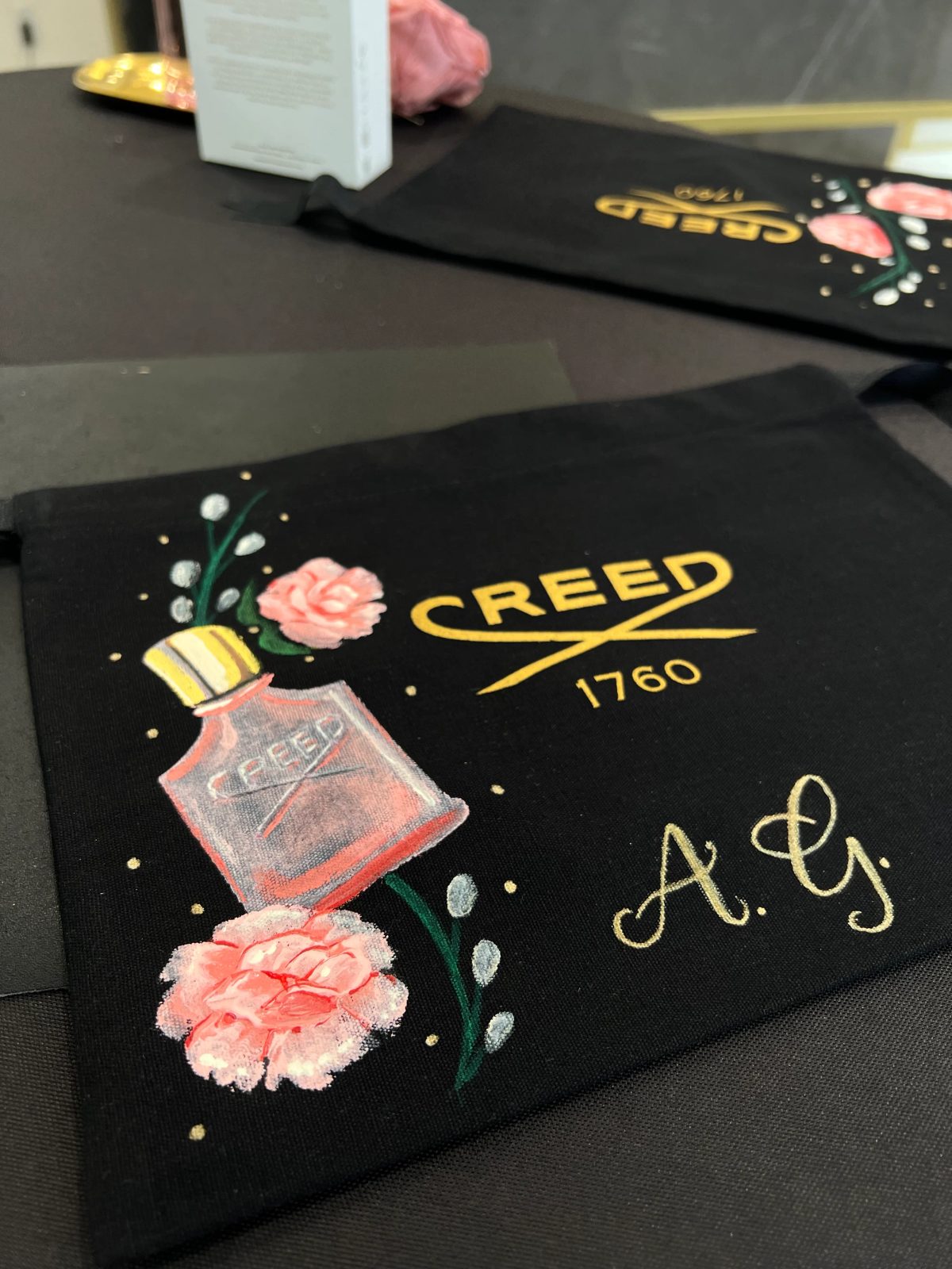 Painted flowers and personalized lettering on black fragrance packaging