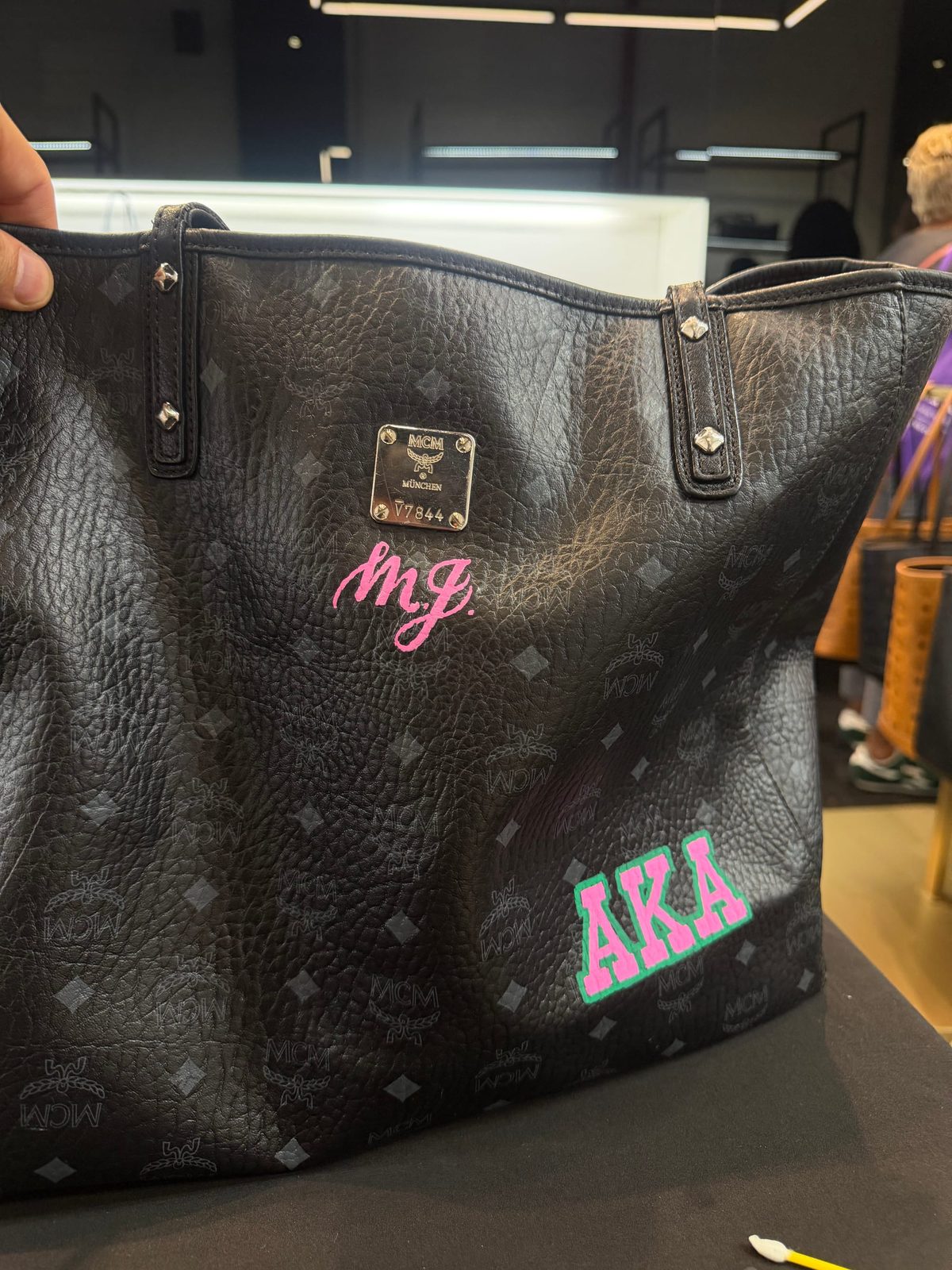 Personalized lettering and painted motifs on a leather bag