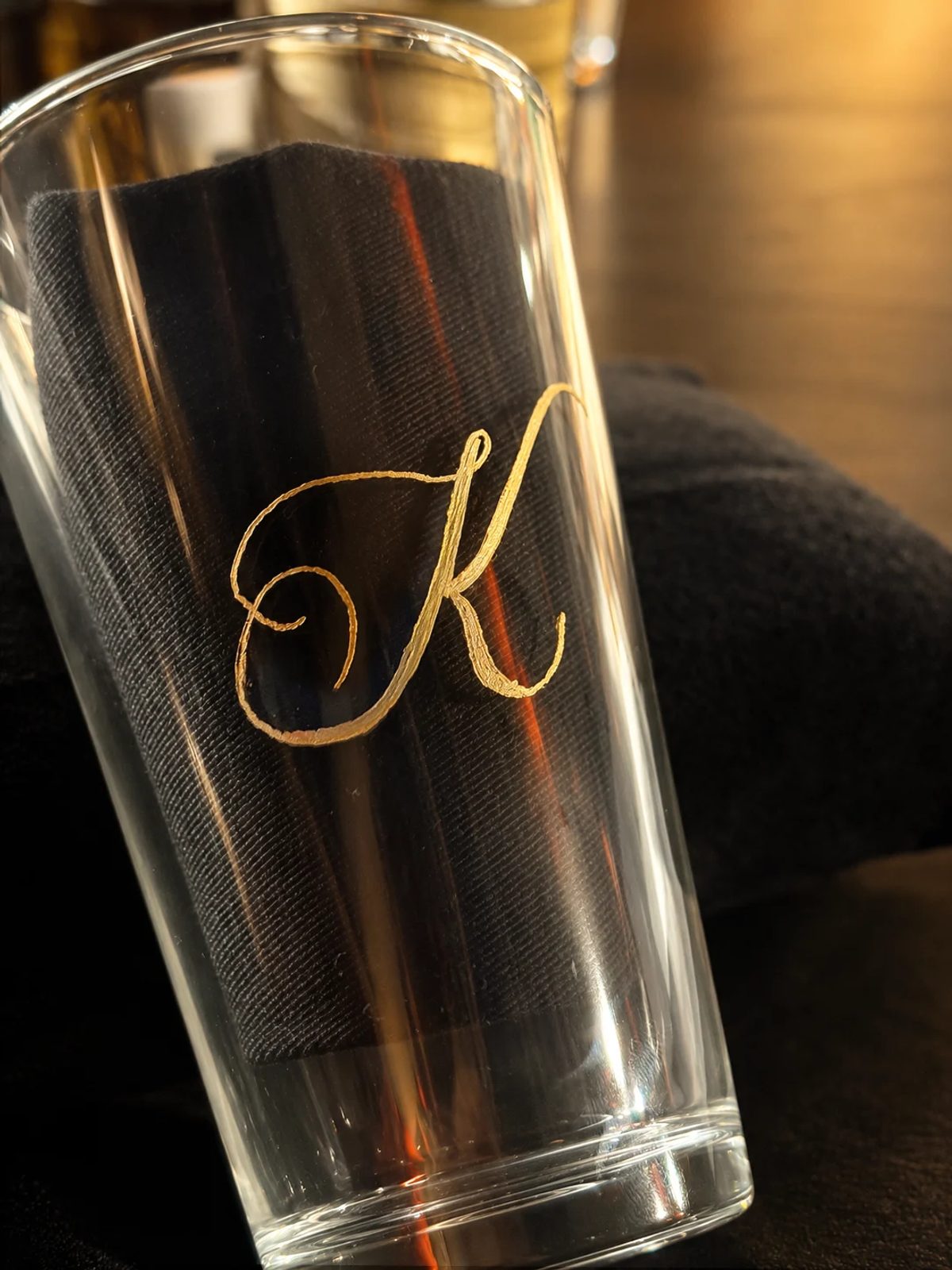 A finished engraved gold initial on a glass