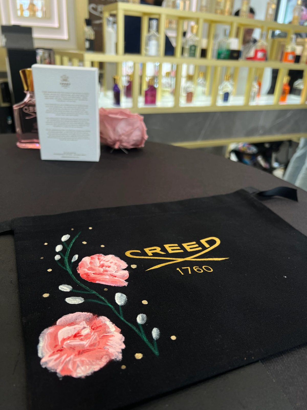 Painted flowers and personalized lettering on black fragrance packaging
