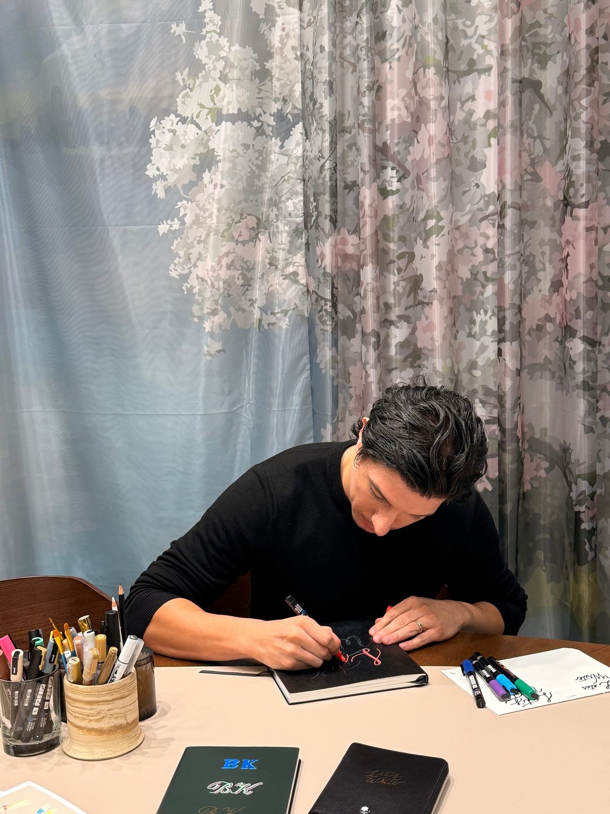Rodolfo working at a calligraphy desk