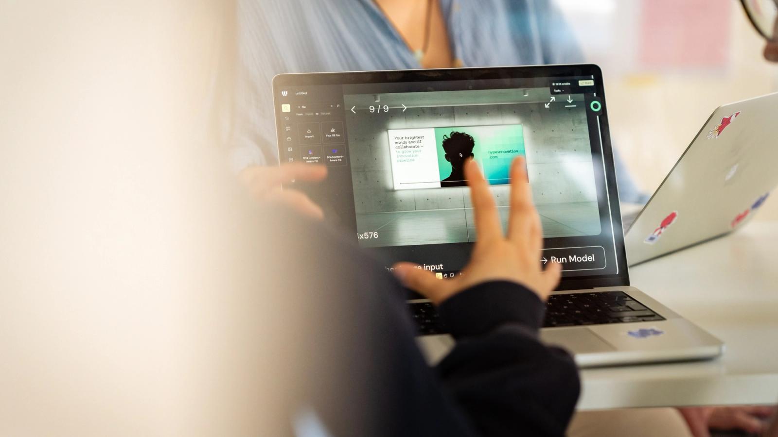 Eine Person arbeitet an einem Laptop mit einer KI-gestützten Anwendung zur Bearbeitung eines digitalen Werbemotivs.