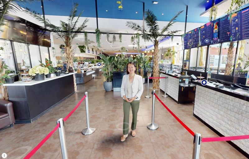 Entrance to an all-you-can-eat buffet, a woman standing between the queue barriers