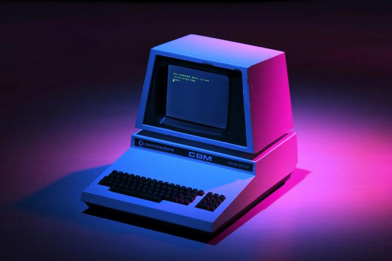 A 1980s personal computer with a CRT screen, lit in pink and blue