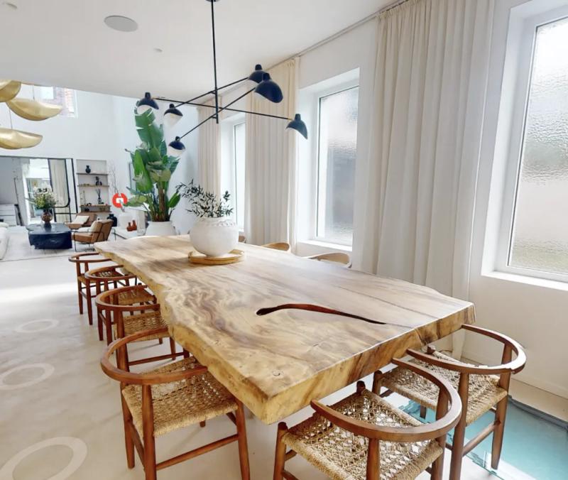 Dining room with a large rough-wood table and woven rope chairs