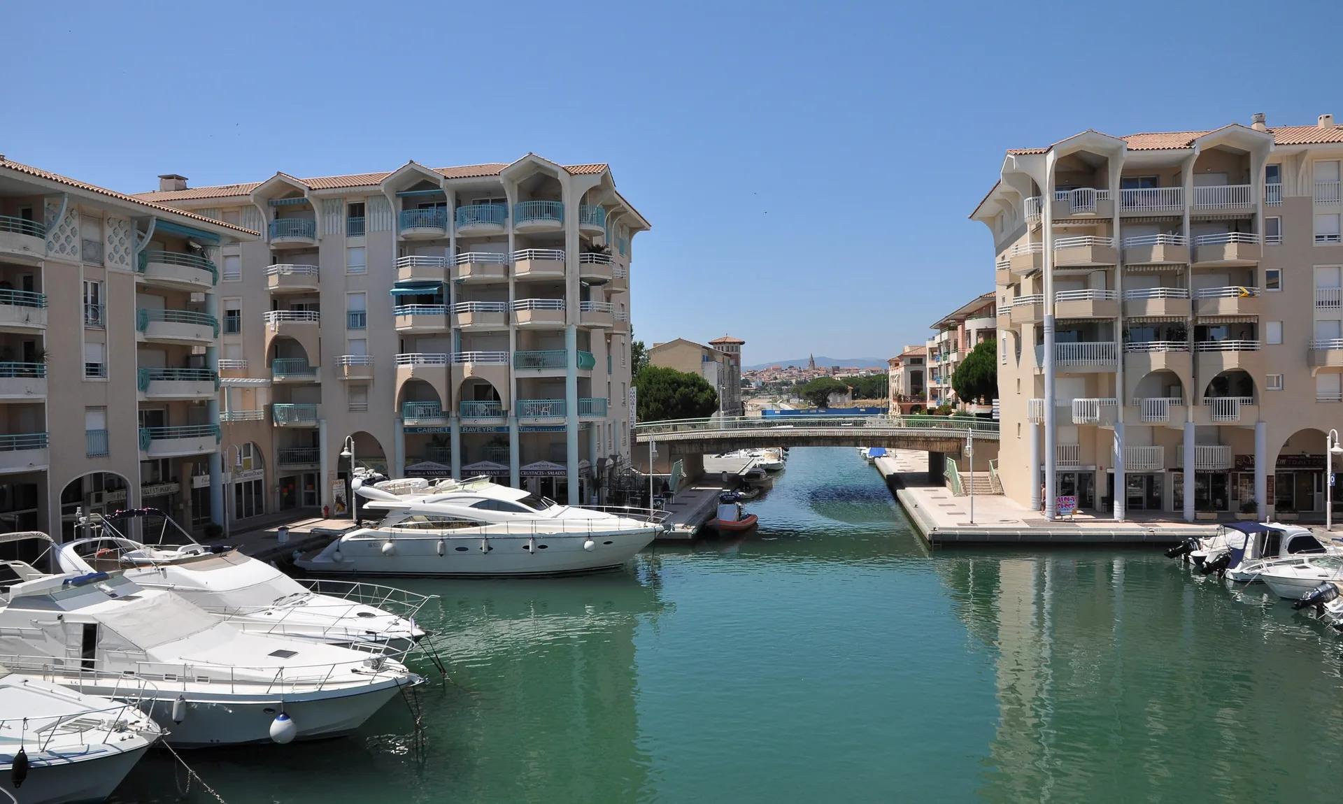 Port-Fréjus, ses quais et ses immeubles aux façades ocre.