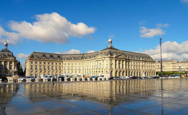 Place de la Bourse in Bordeaux reflected in the Miroir d’eau under a blue sky