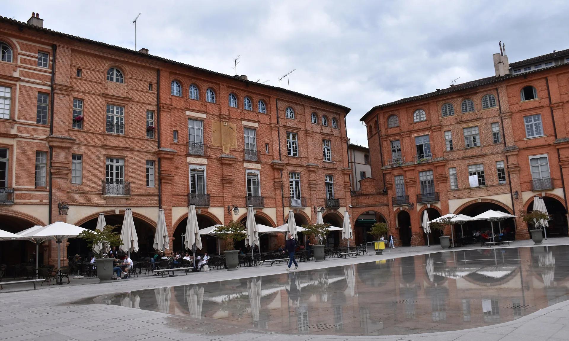 La place Nationale de Montauban, ses arcades et ses façades de brique rose.
