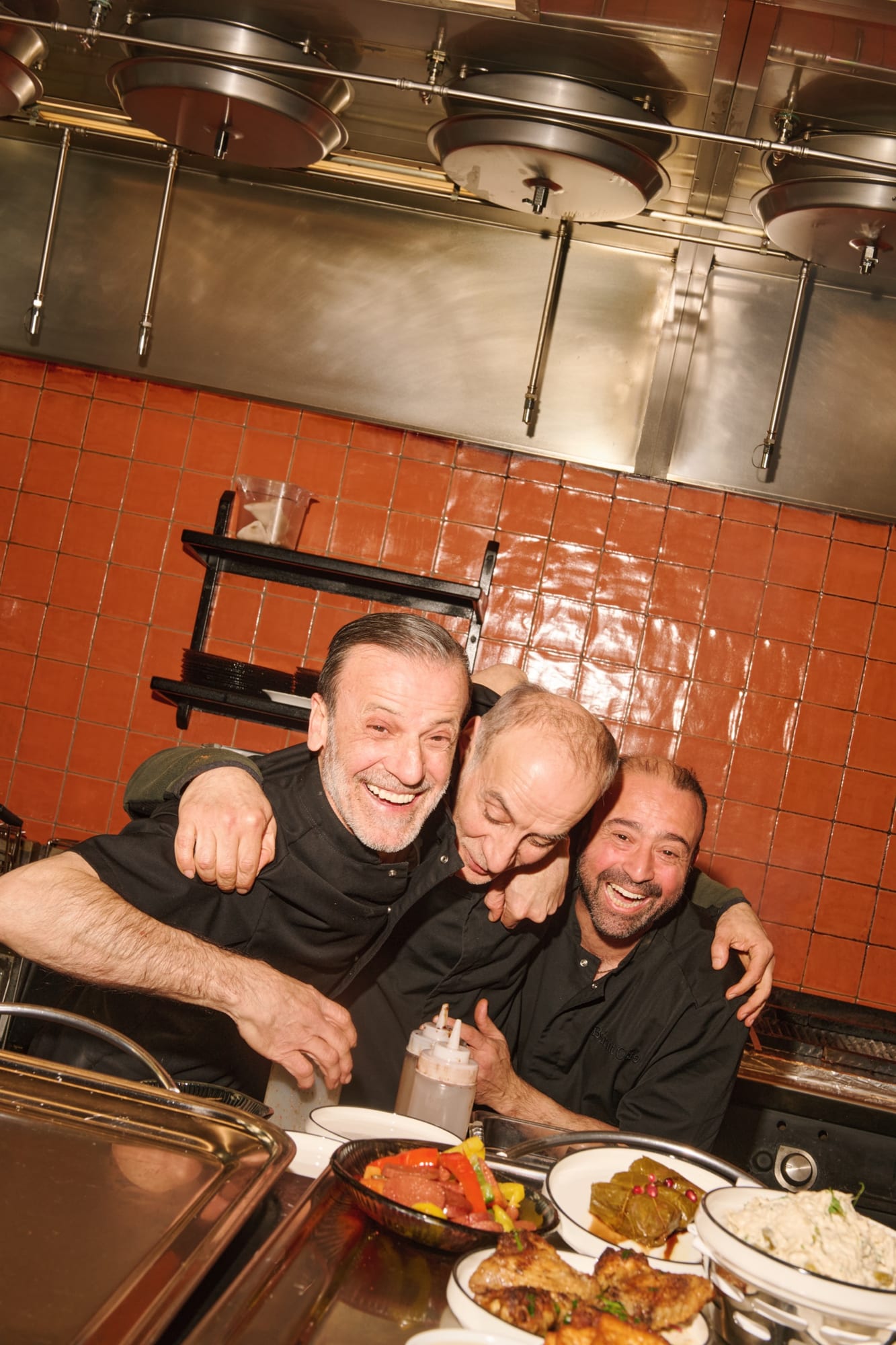 Tre kockar skrattar tillsammans bakom disken på Beirut Café
