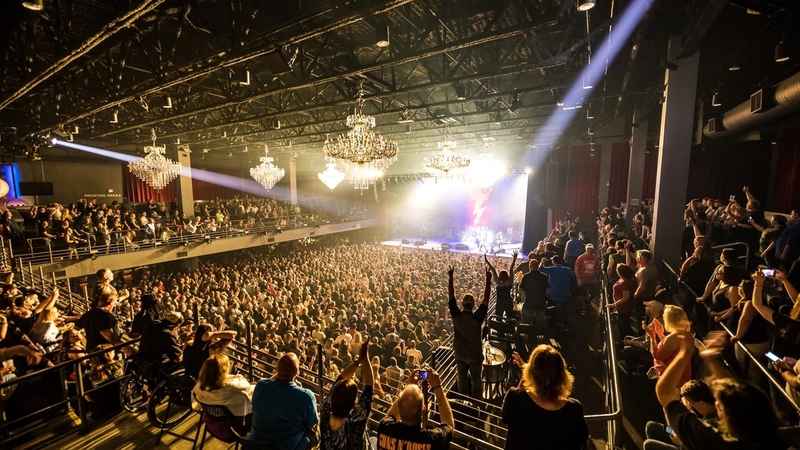 Photo from the back right corner of the 2nd floor of the Coca-Cola Roxy venue. Fans on the balcony are seated and standing while the first floor crowd is standing in front of the production.
