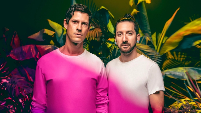 Big Gigantic Duo Press Photo on a floral background with a pink hue stretching across their shirts