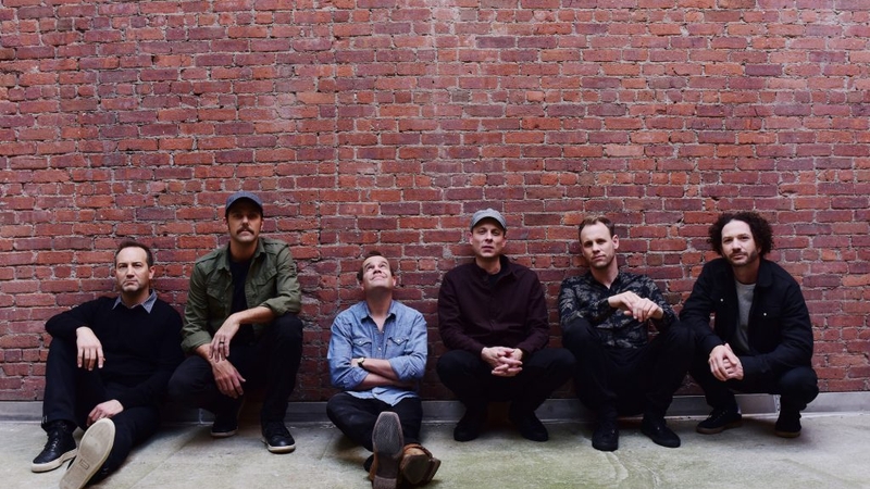 Umphrey's McGee Sitting against a red brick wall
