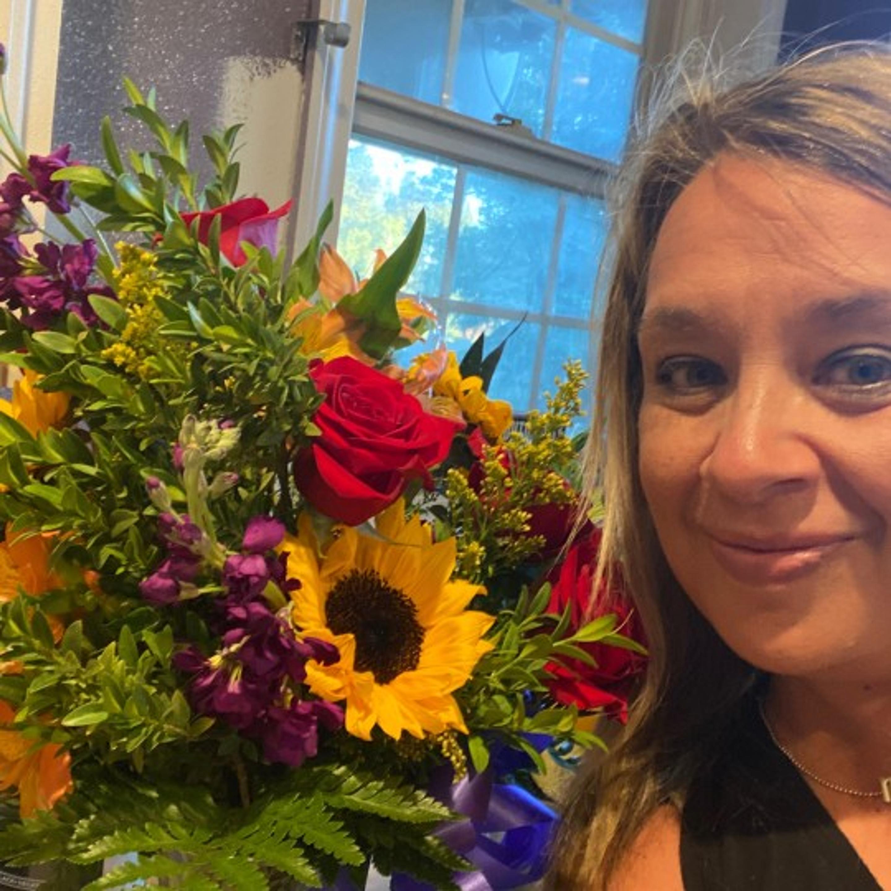 Thanks Image with Flowers in frame and woman smiling with roses and sunflowers