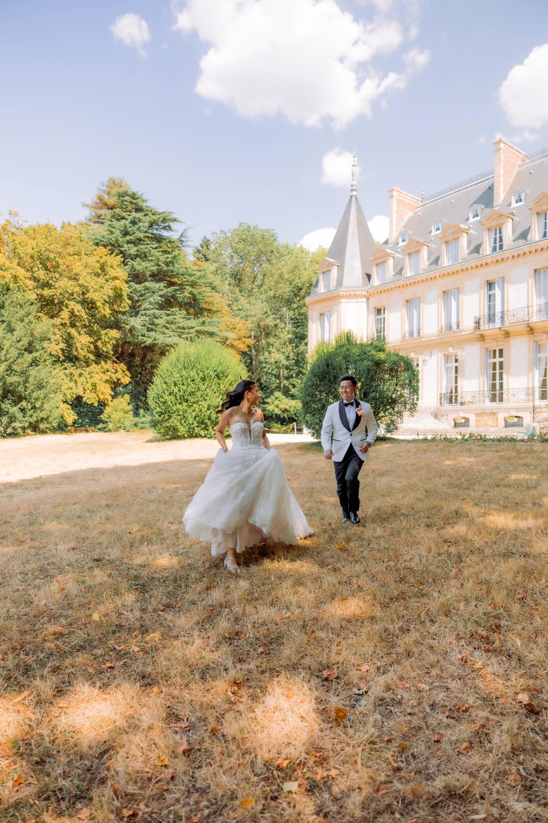 Les mariés traversent le parc devant le Château de Santeny