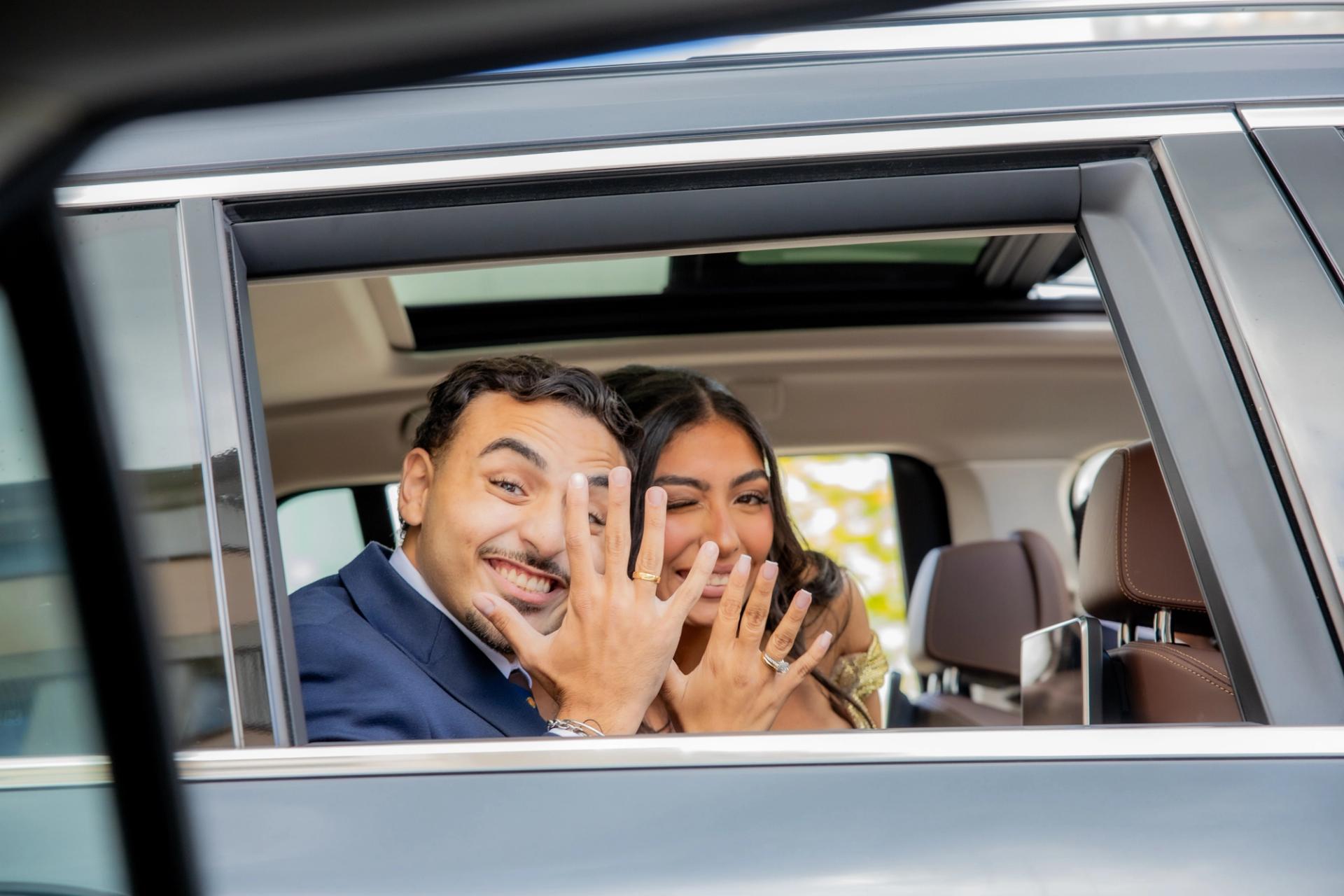 Les mariés montrent leurs alliances depuis la voiture