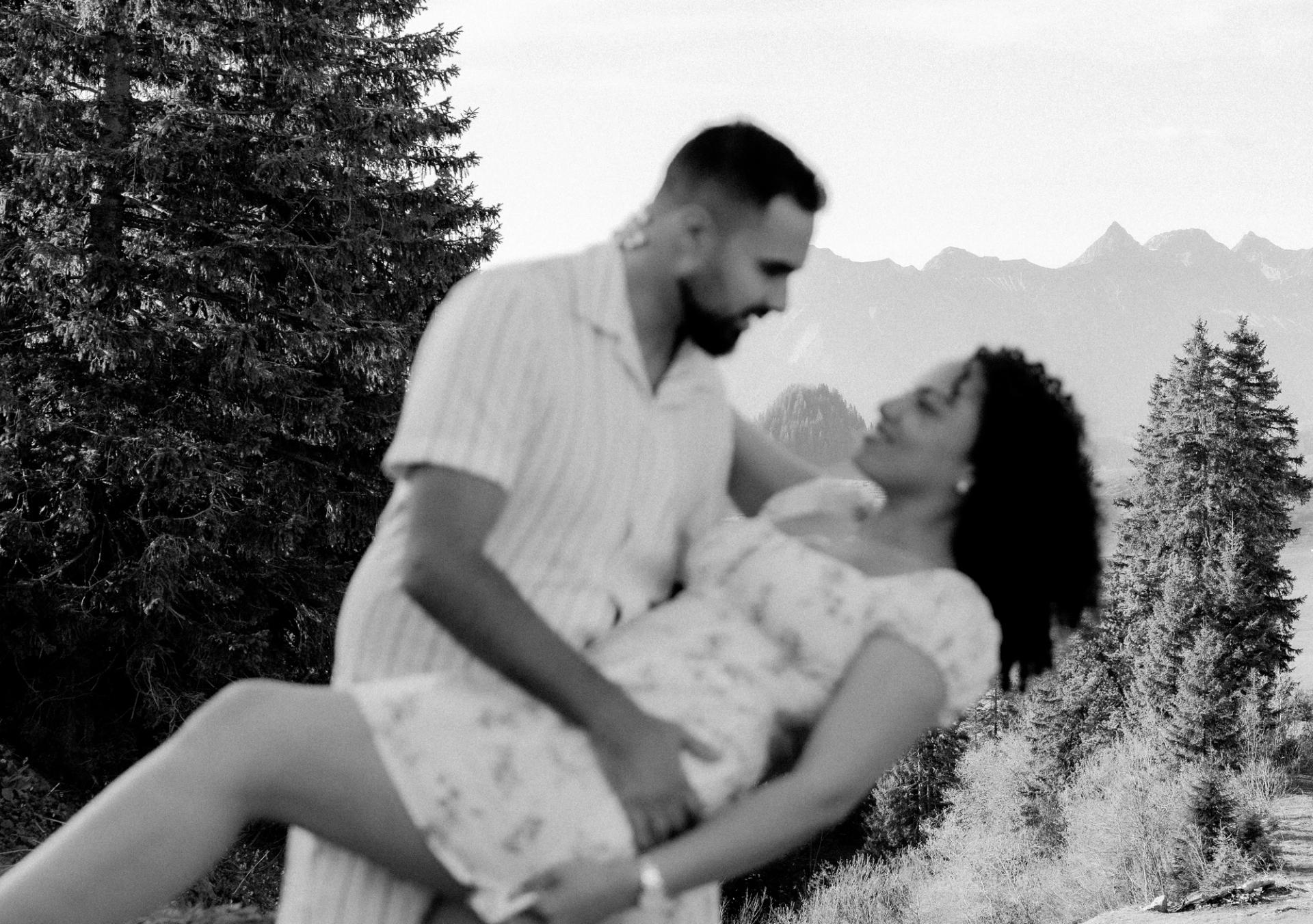 Rafaël porte Julia face aux montagnes en noir et blanc