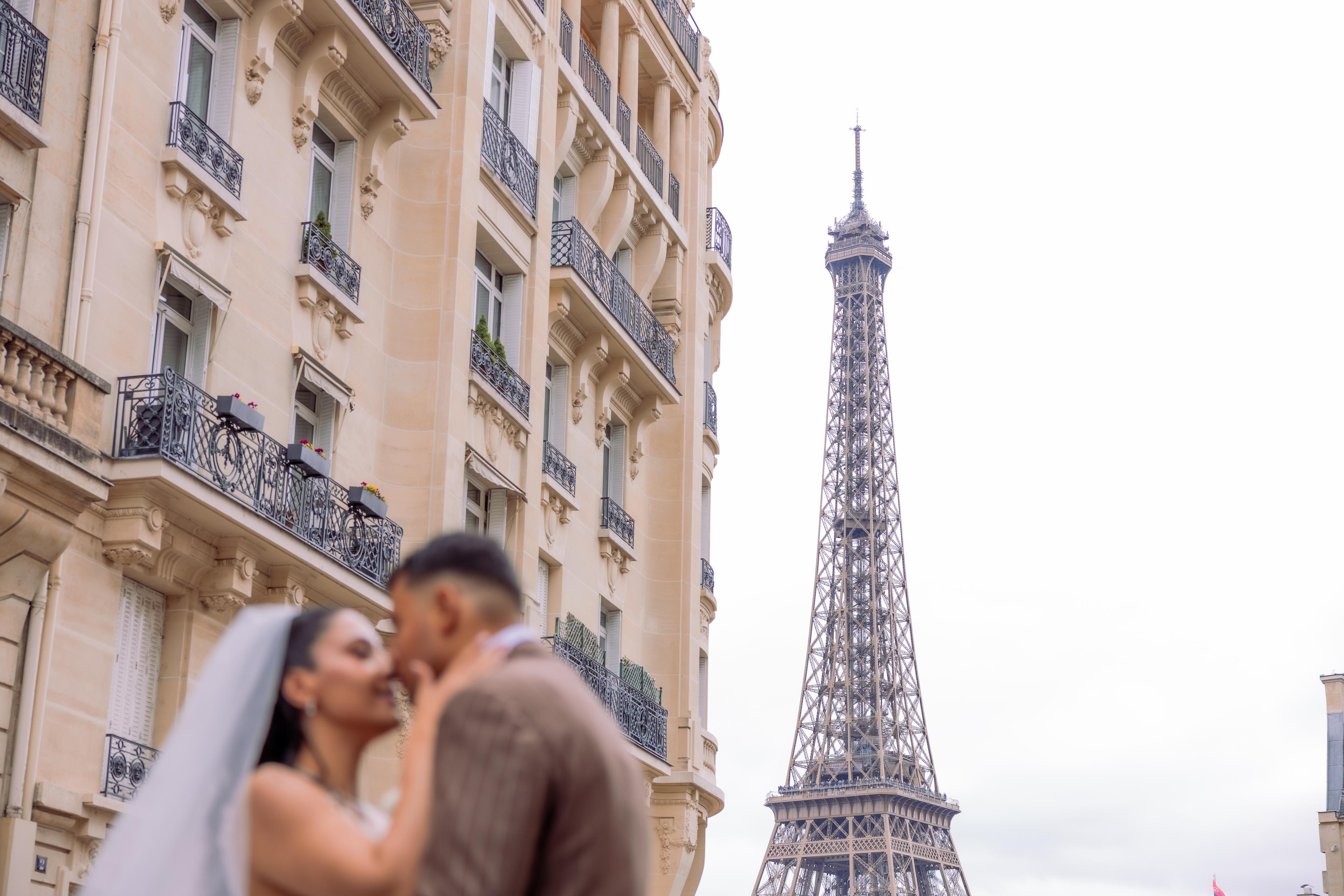 Baiser des mariés dans une rue avec la tour Eiffel