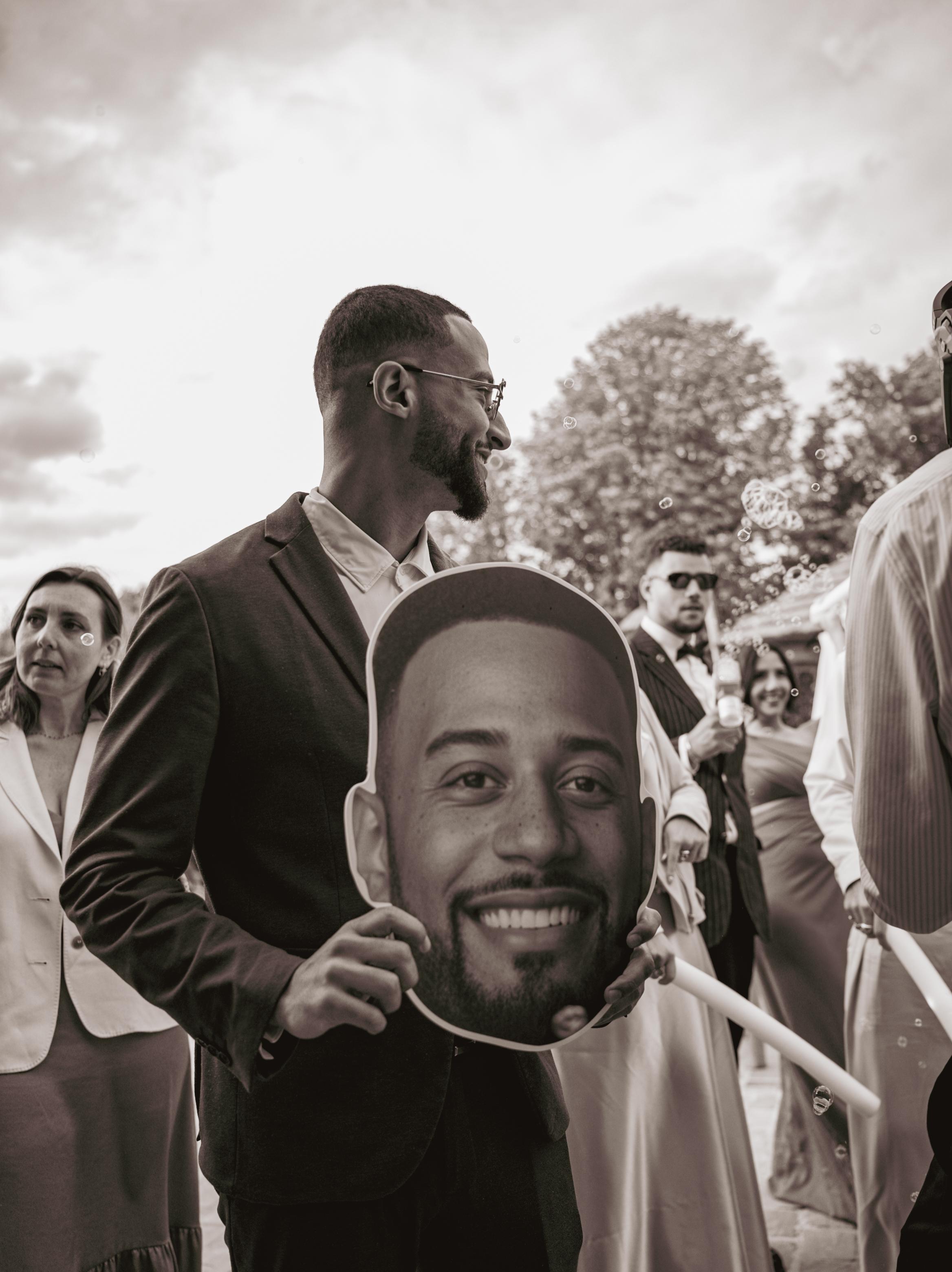 Un invité tient un portrait de Loïc au milieu de la foule