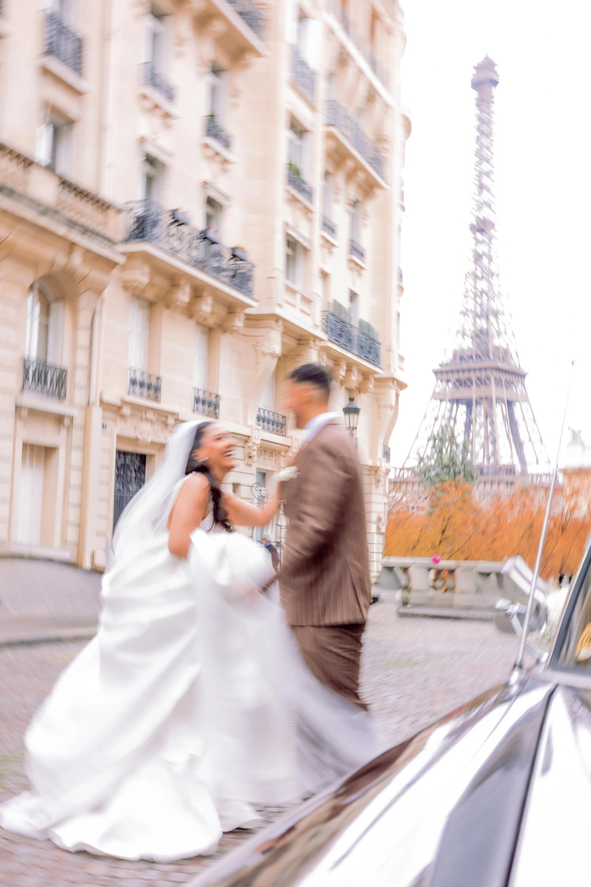Baiser des mariés devant la tour Eiffel et la voiture