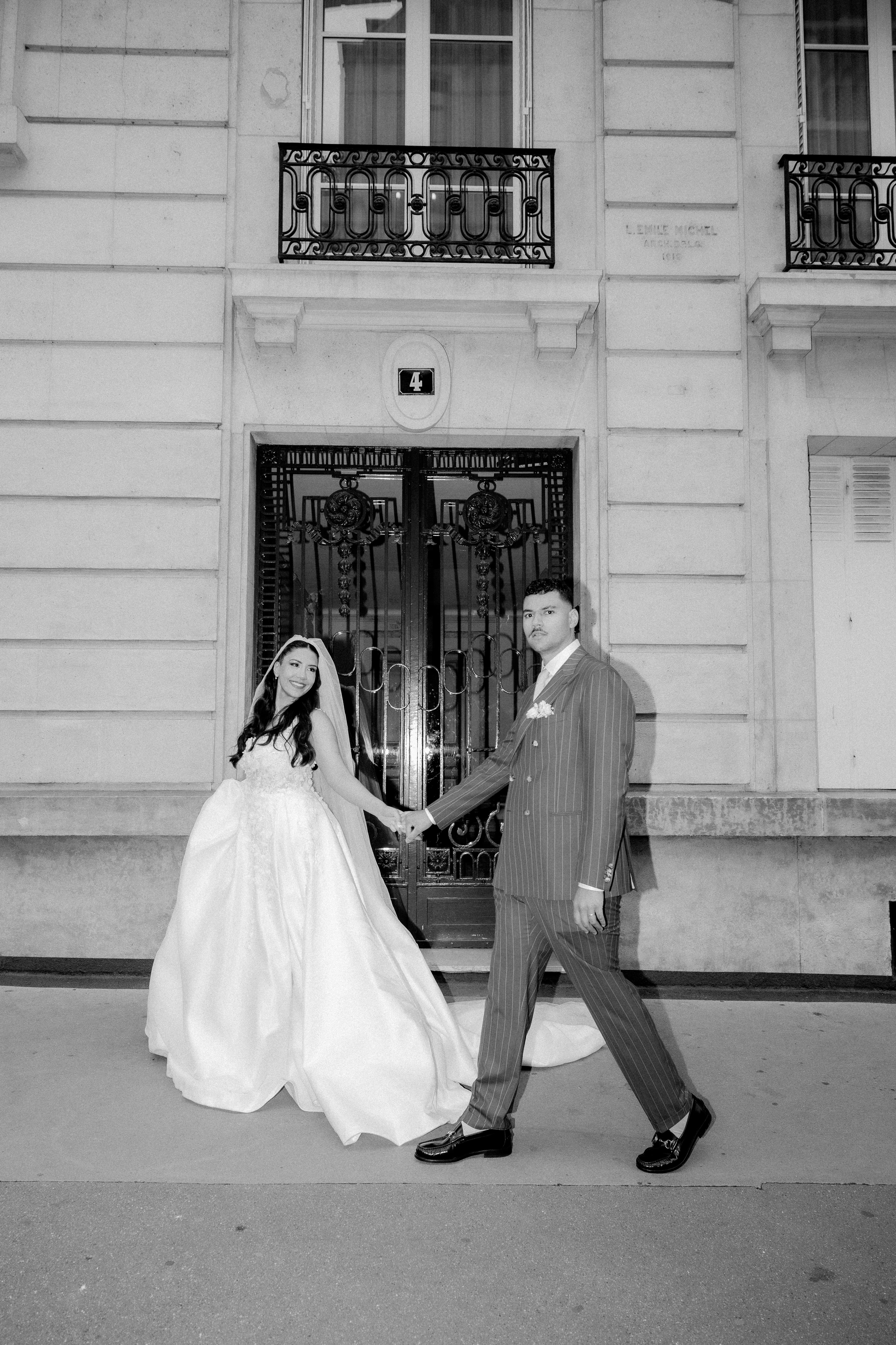 Les mariés marchent dans une rue parisienne en noir et blanc