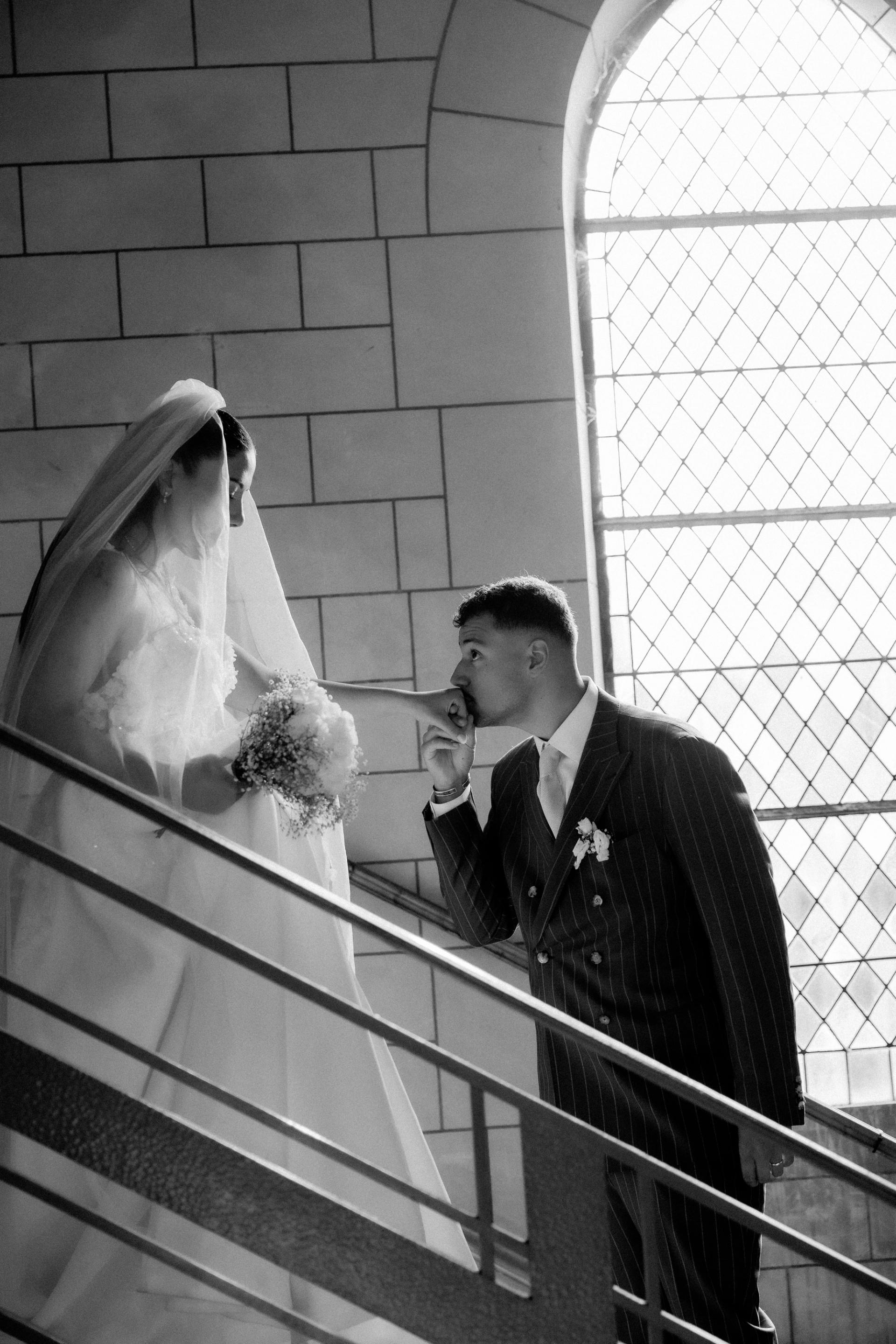 Les mariés rient avec le prêtre pendant la cérémonie en noir et blanc