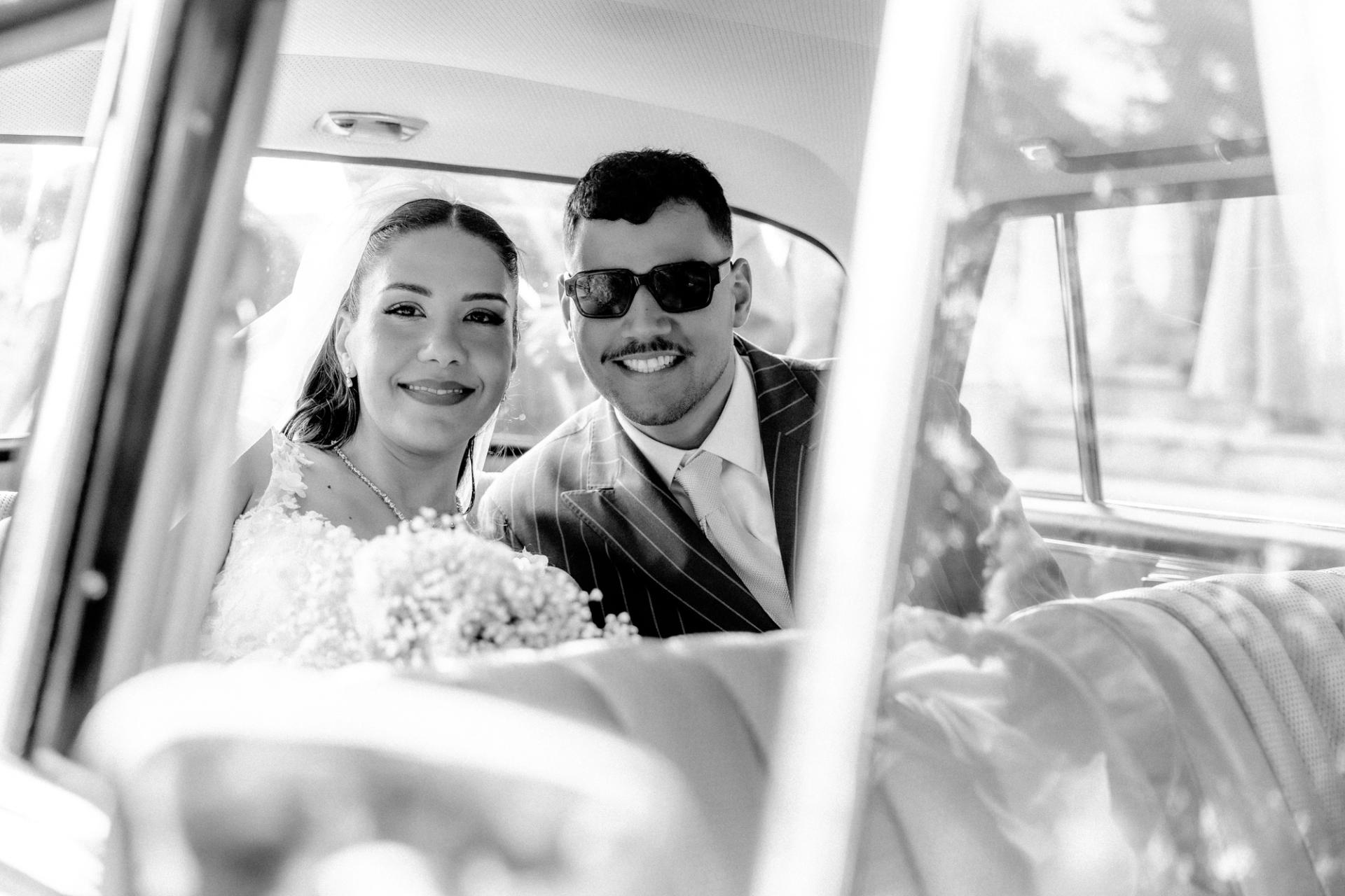 Marie Ange et William sourient dans la voiture en noir et blanc