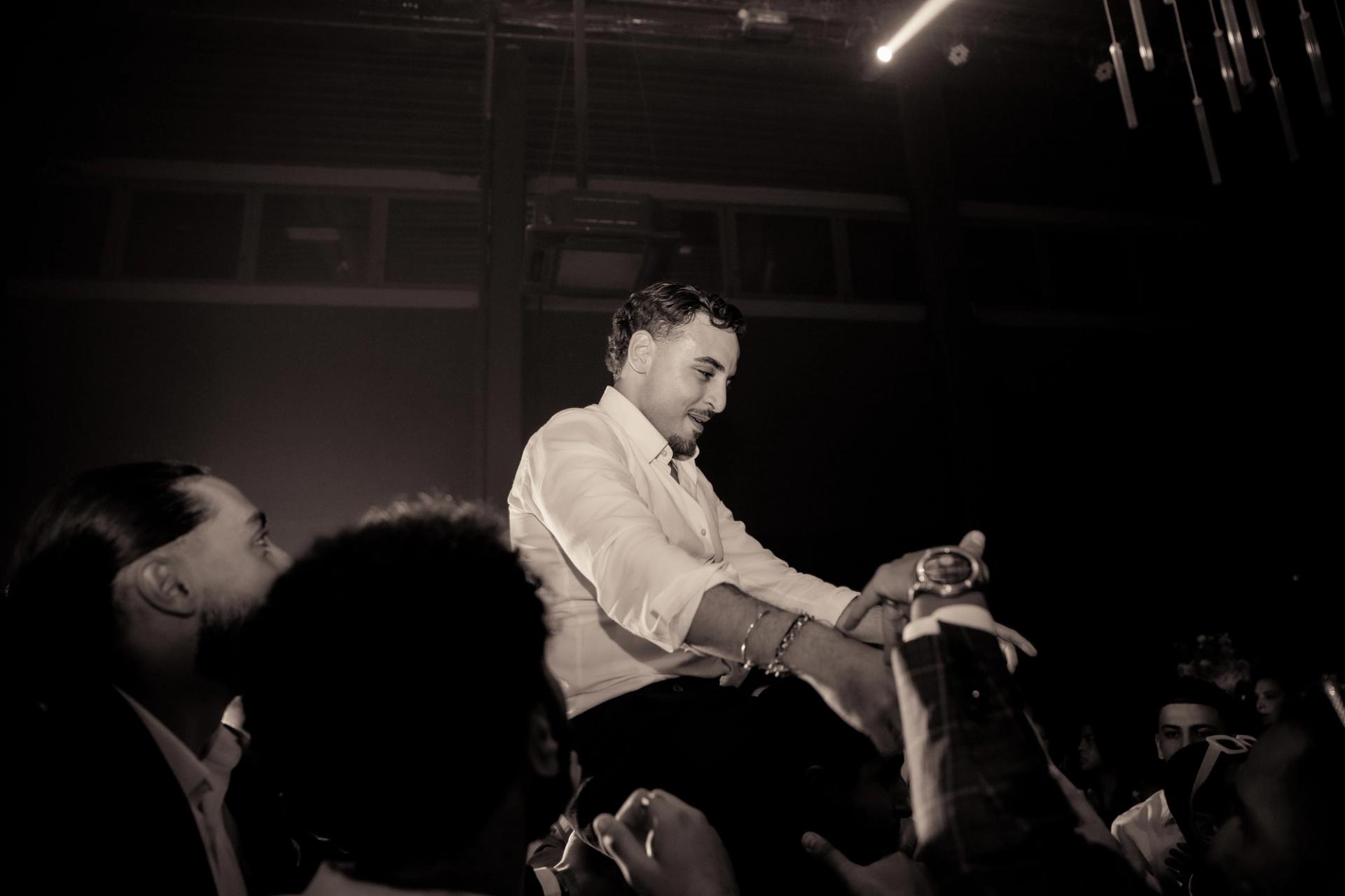 Marco est porté par ses proches en noir et blanc