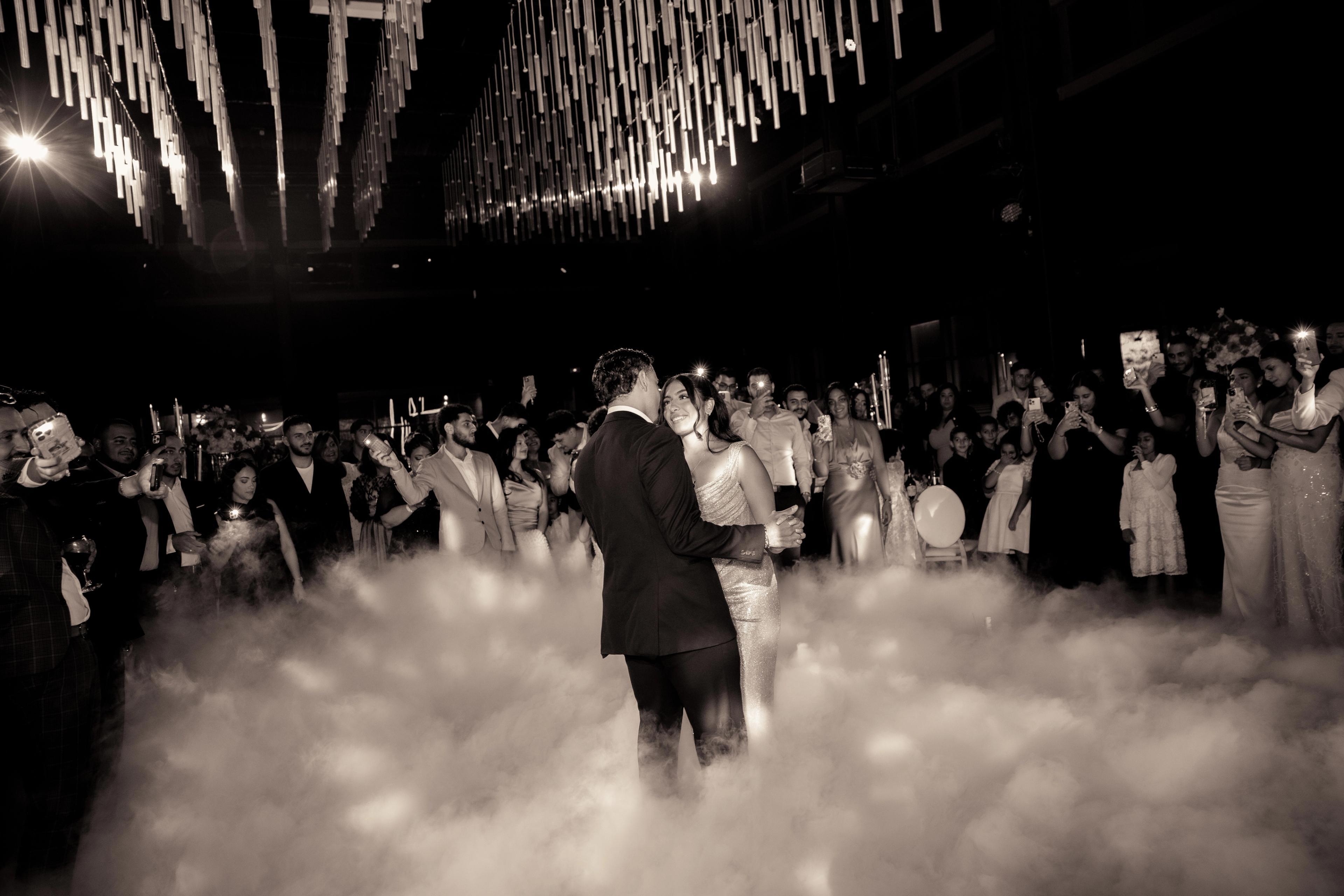 Première danse dans la fumée sous les lumières en noir et blanc