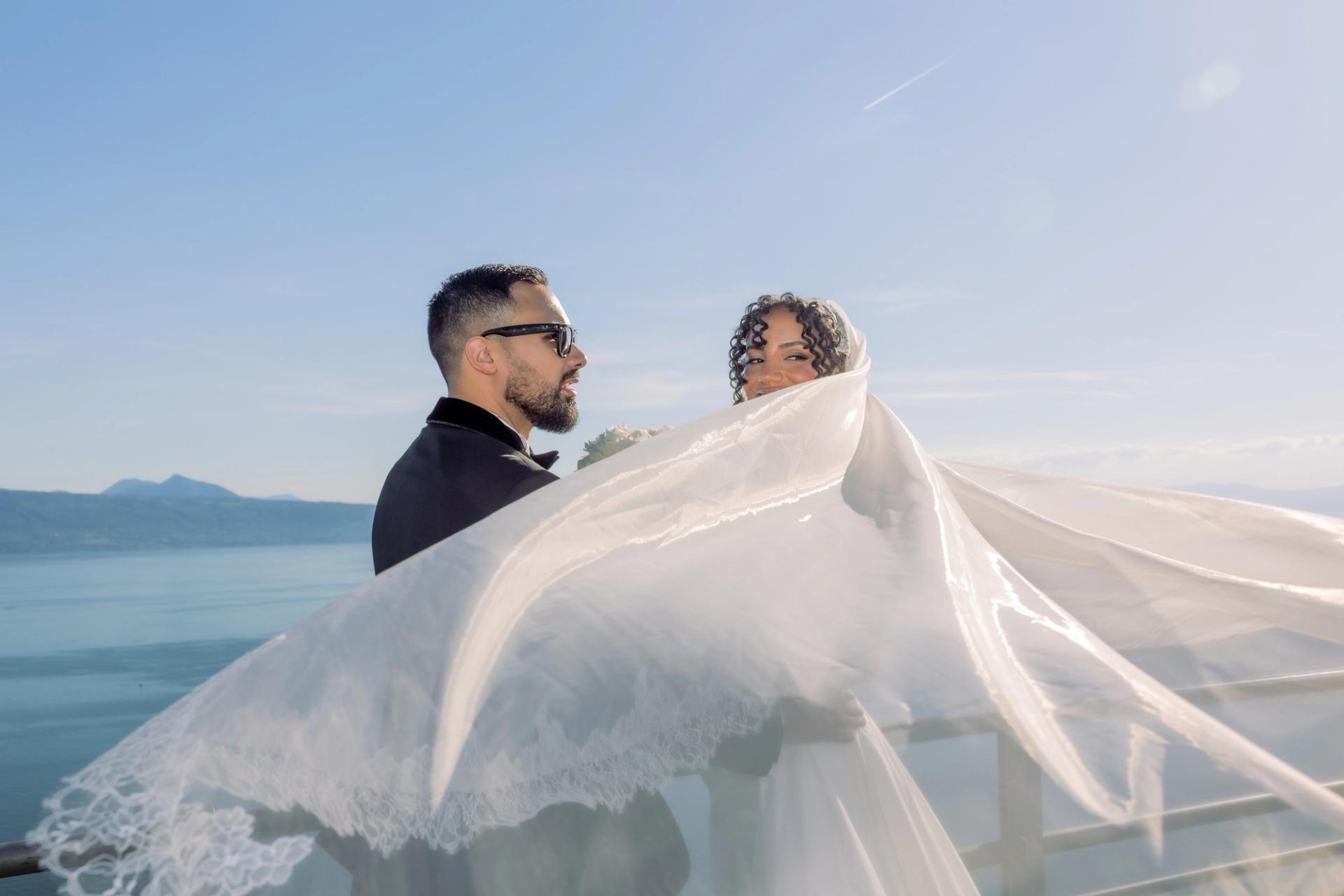 Les mariés face au lac entourés par le voile de Julia