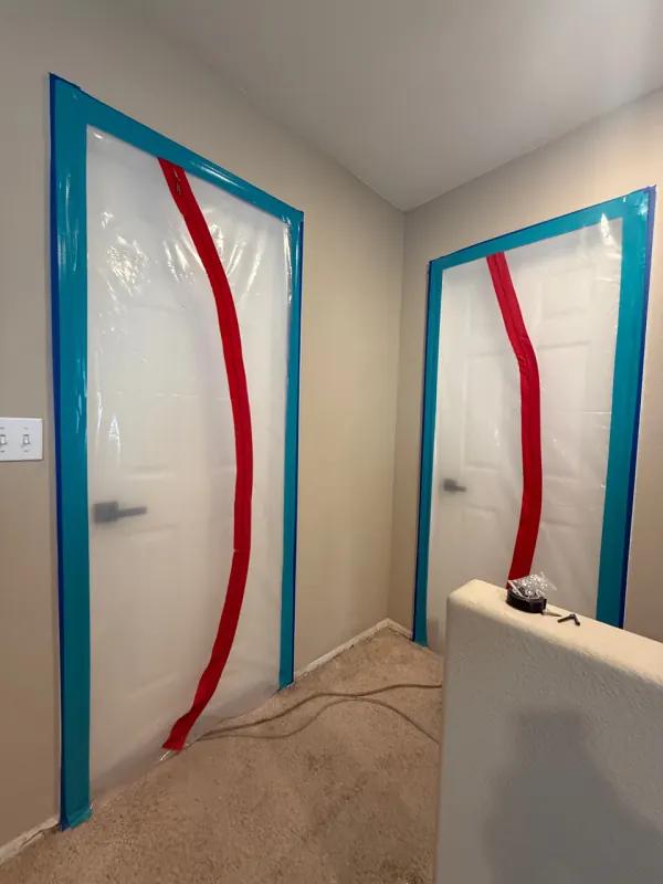 Containment barrier and drying equipment isolating a water-damaged room in a Henderson home