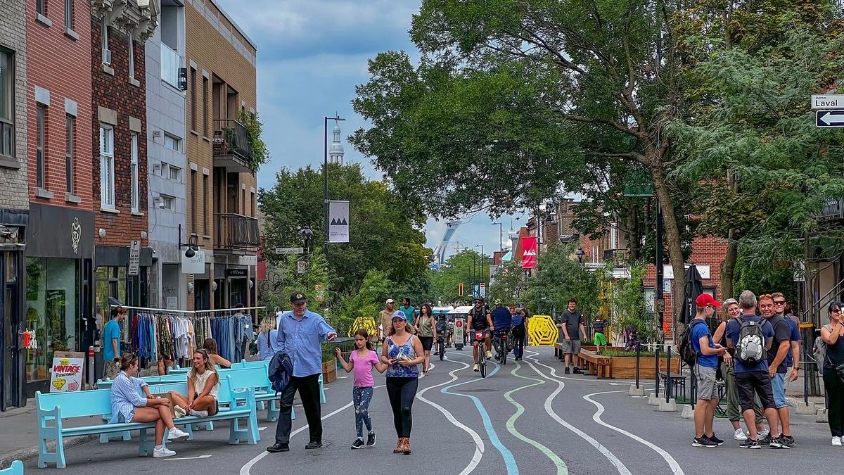 Montreal's Mont-Royal Avenue walked by families and friends in the warmth of summer with green leaves on trees.