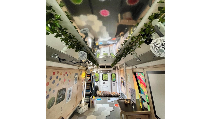 The inside of the Cartie art gallery inside a bus. Full of colorful artwork. 