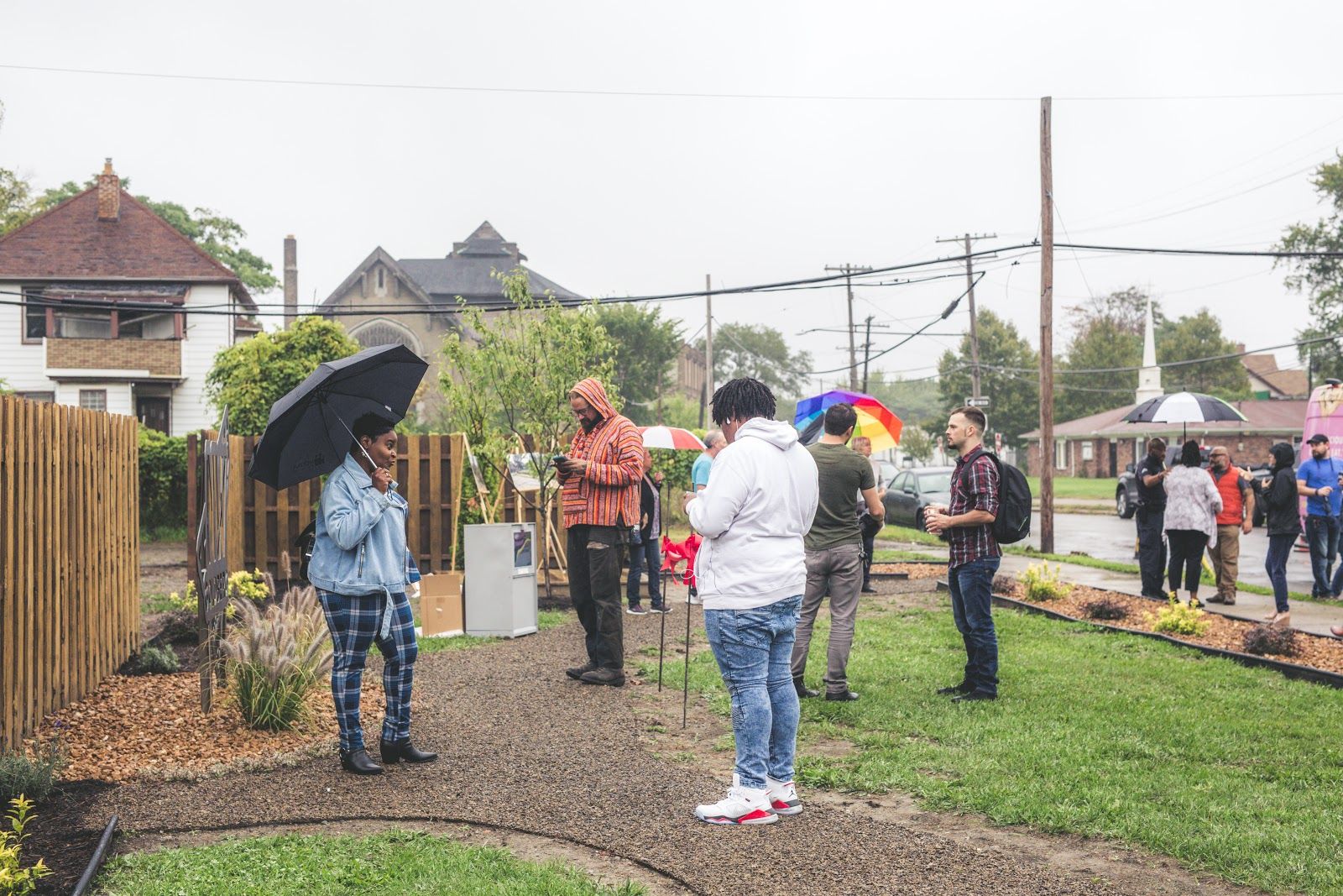 A community gathering in the rain at the Art Park