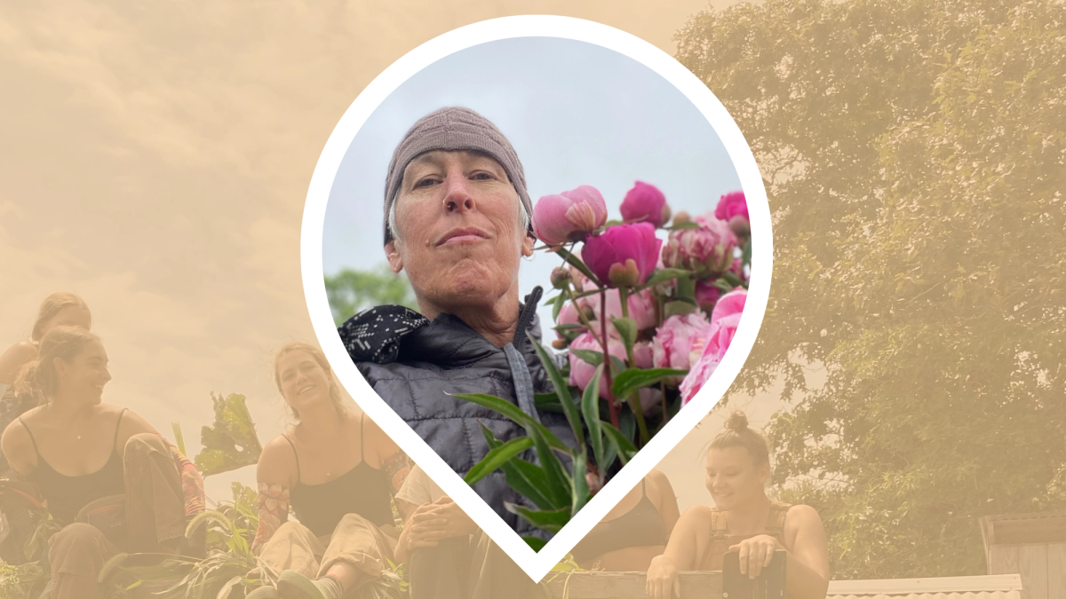 Rebecca Miller, a white woman with short white hair, wears a beige beanie and holds pink peonies close to her face. 