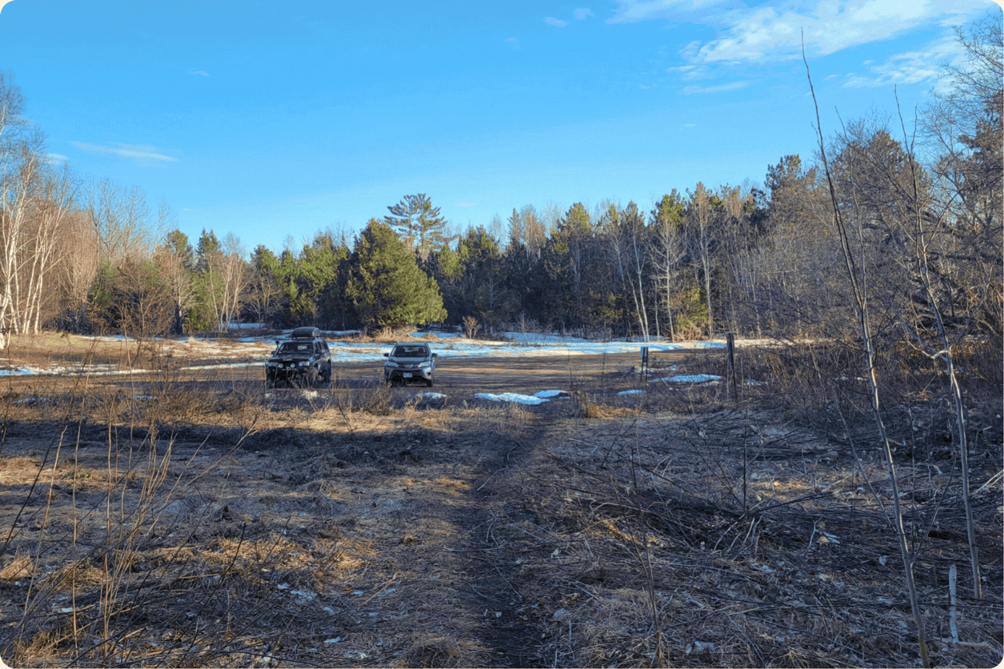 A before-and-after transformation of the area near the parking lot. The before image wipes away to reveal clean, clear tracks with a fresh sign. 