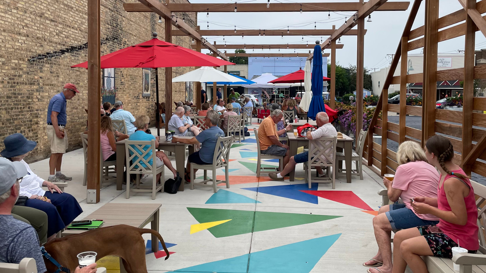 Bridgman Courtyard, a vibrant courtyard featuring a wooden pergola above public seating and a colorful, abstract ground mural.