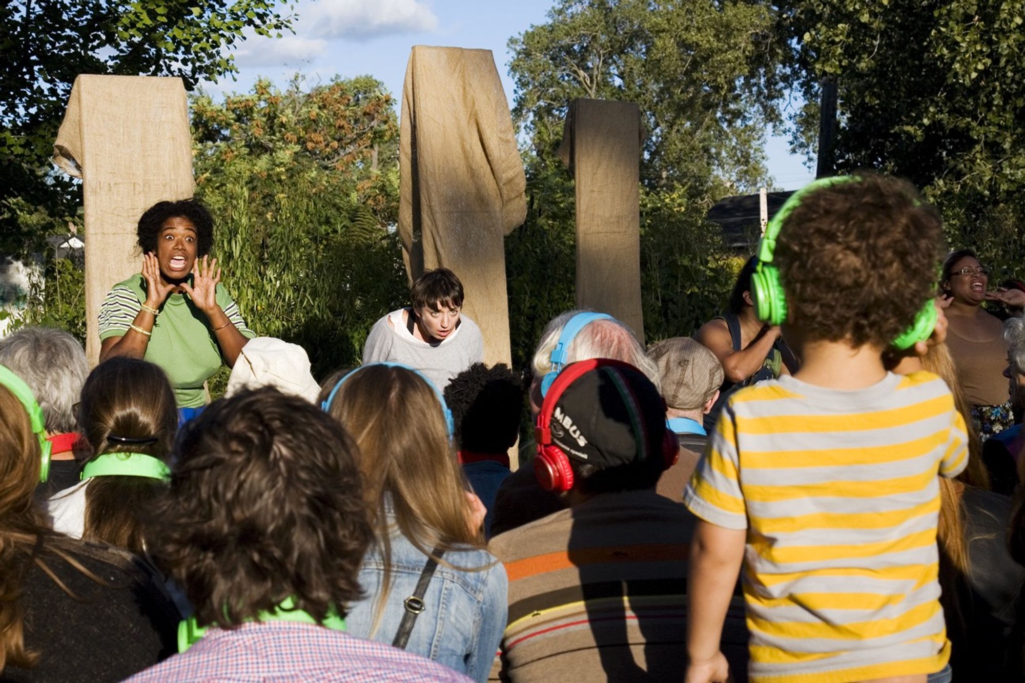 Two people perform a skit for a group of kids.