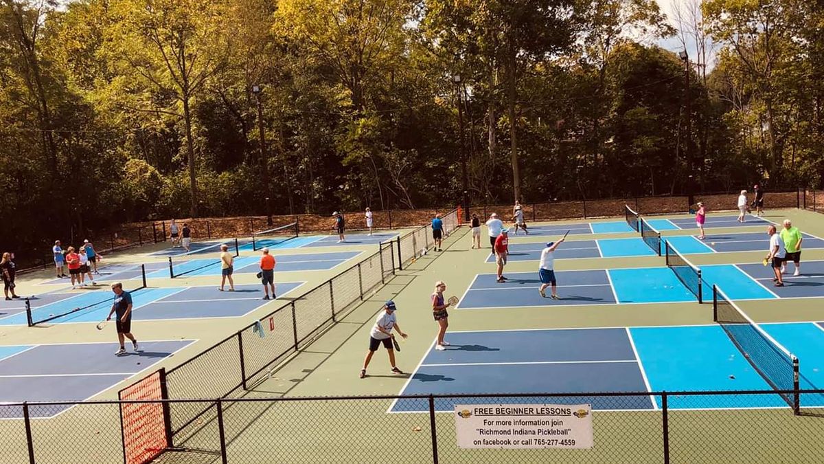 Pickleball being played on a new sports court by many individuals. 