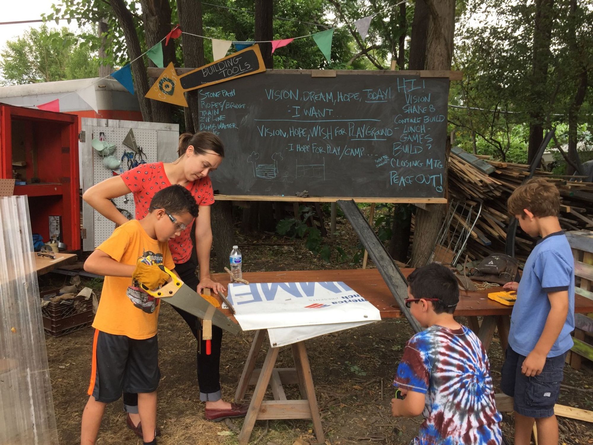 Camp Carpenter in action! Youth learn to use hand tools, like a handsaw. 